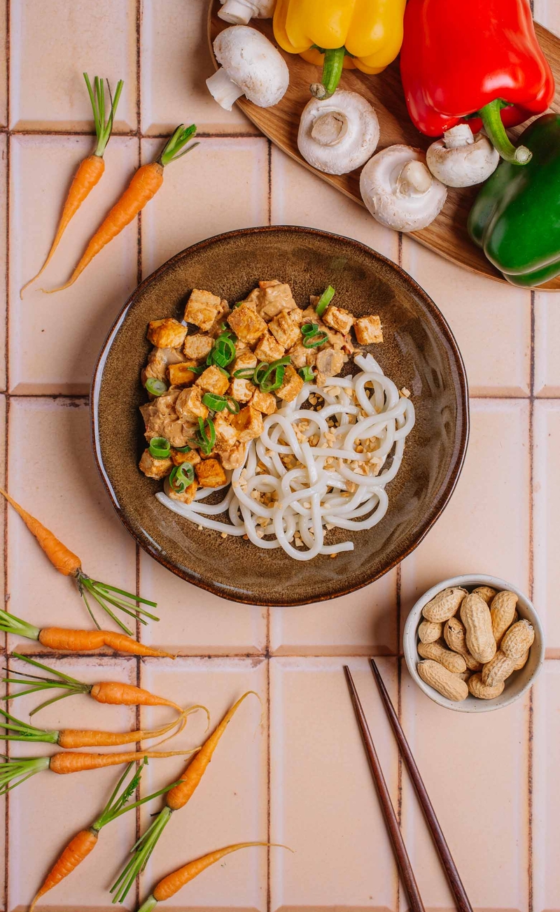 Makaron udon z tofu, papryką, pieczarkami i marchewką w sosie orzechowym satay