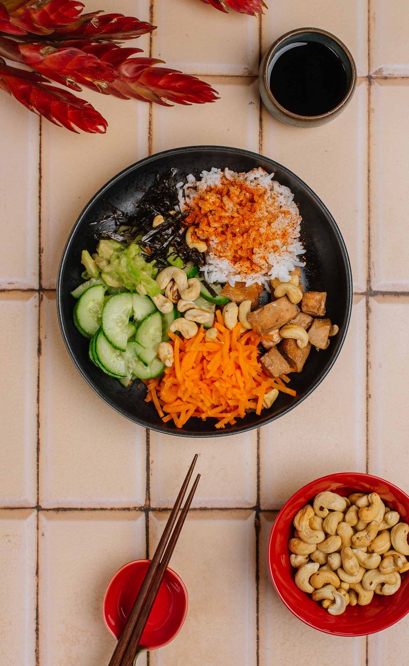 Sushi bowl z łososiem, nori, ryżem, awokado, ogórkiem, orzechami nerkowca i sosem sojowym