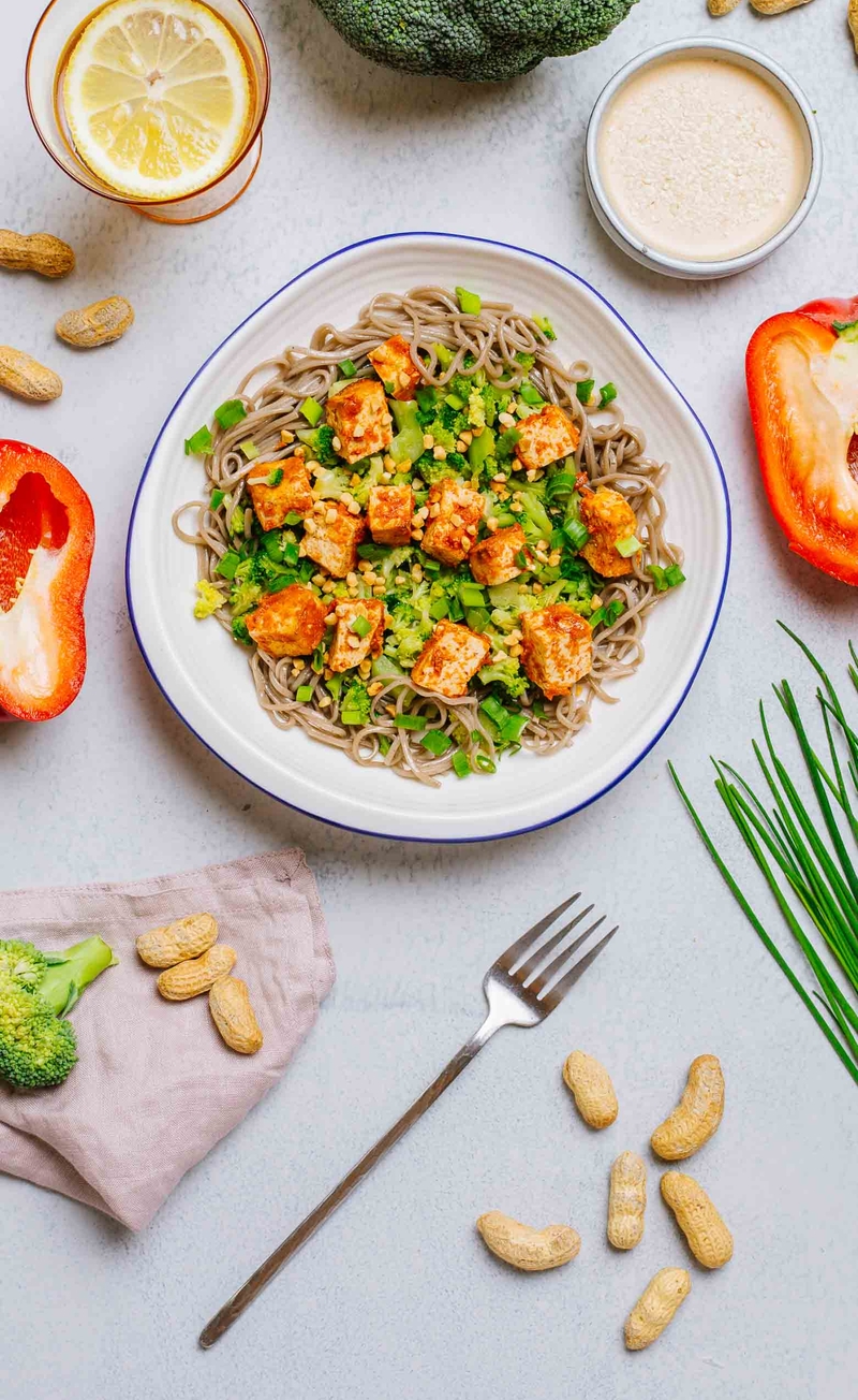Makaron soba z paprykowym tofu z sosem sezamowym z brokułami, szczypiorem i orzeszkami ziemnymi
