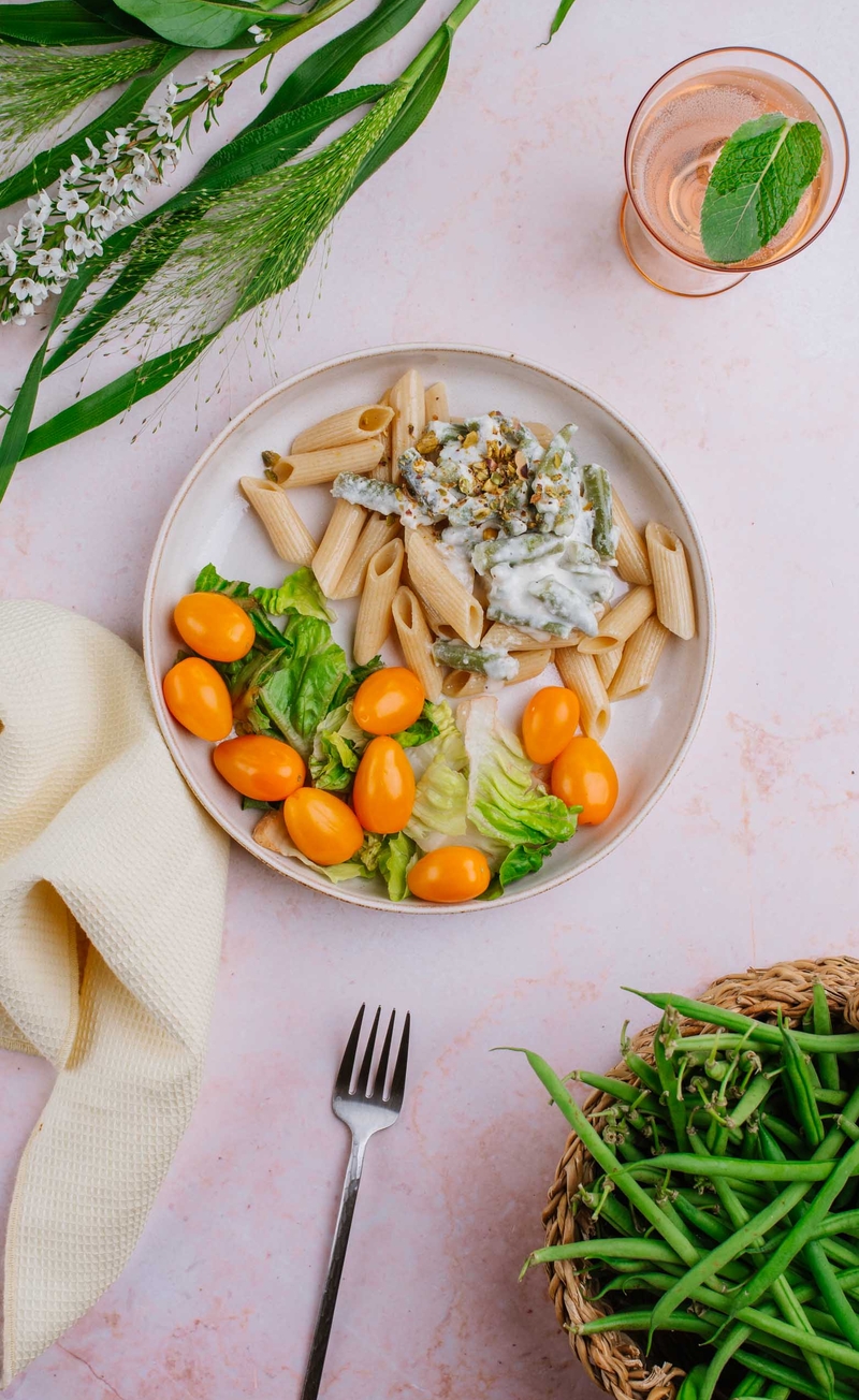 Pełnoziarniste penne w sosie śmietankowym z fasolką szparagową, sałata rzymska z pomidorkami