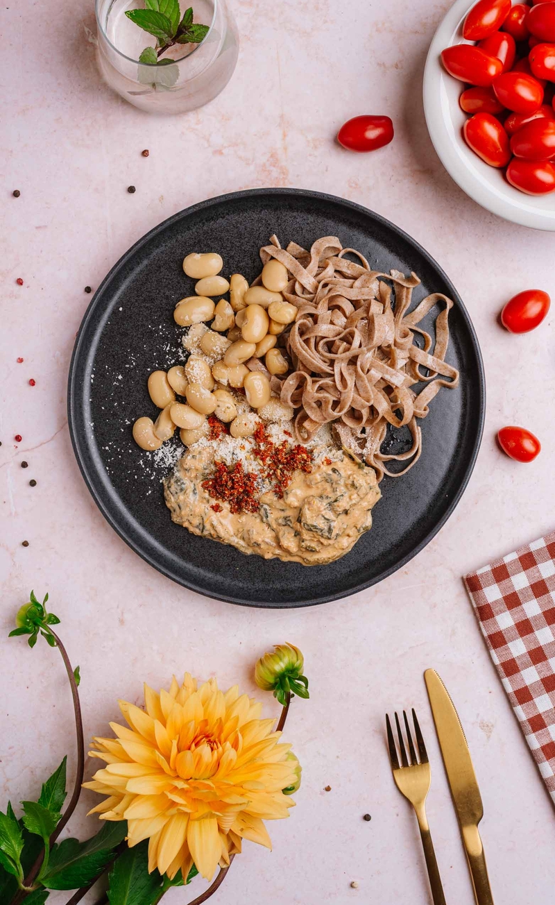 Fasola Jumbo w kremowym sosie z suszonymi pomidorami, szpinakiem i parmezanem, orkiszowe tagliatelle