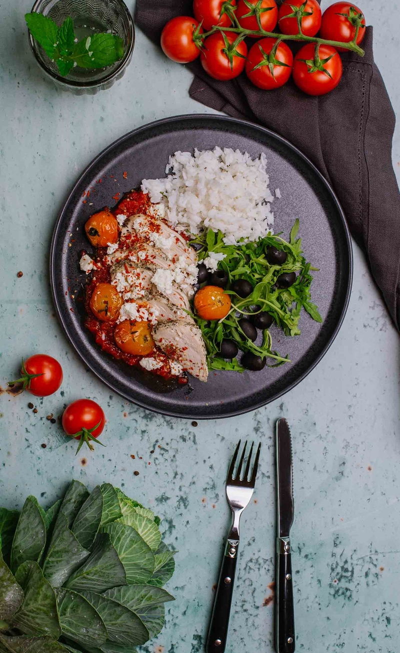 Kurczak w mocno pomidorowym sosie z pokruszoną fetą, ryż basmati, rukola z oliwkami