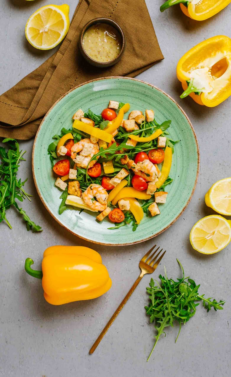 Sałatka z krewetkami smażonymi z papryczką chilli, czosnkiem i cytryną z pomidorkami daktylowymi i rukolą, ziołowe grzanki, dressing cytrynowy