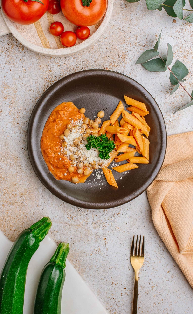 Makaron penne w kremowym sosie pomidorowym z cukinią, ciecierzycą i parmezanem