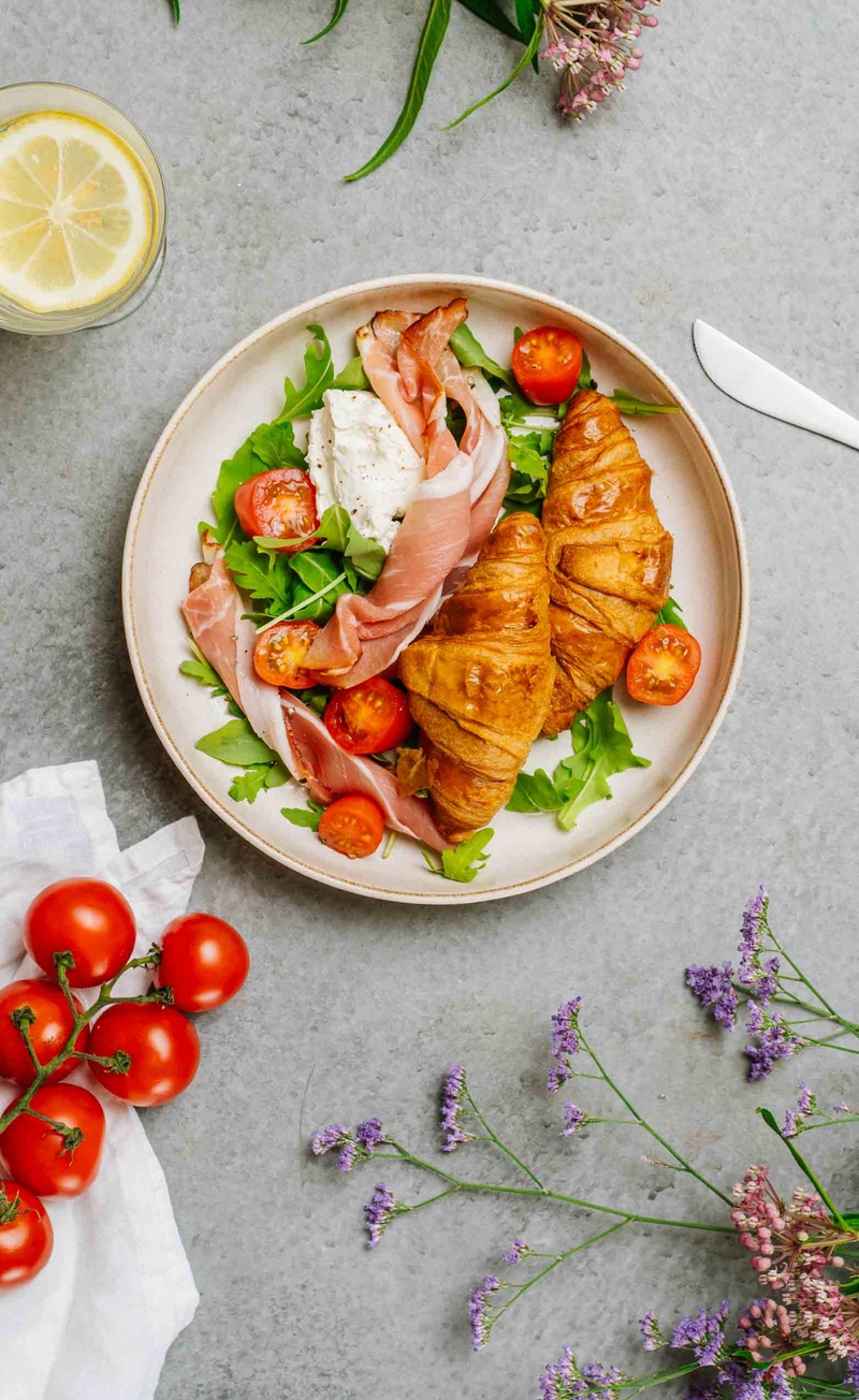 Francuski croissant maślany, serek śmietankowy z pieprzem, szynka dojrzewająca, rukola z pomidorkami