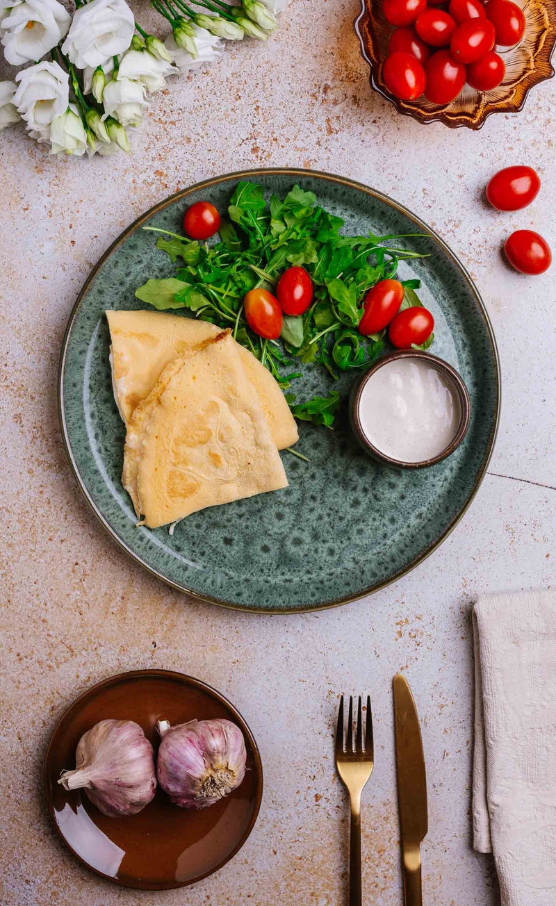 Omlet z mozzarellą, rukola z pomidorkami, pikantny sos czosnkowy