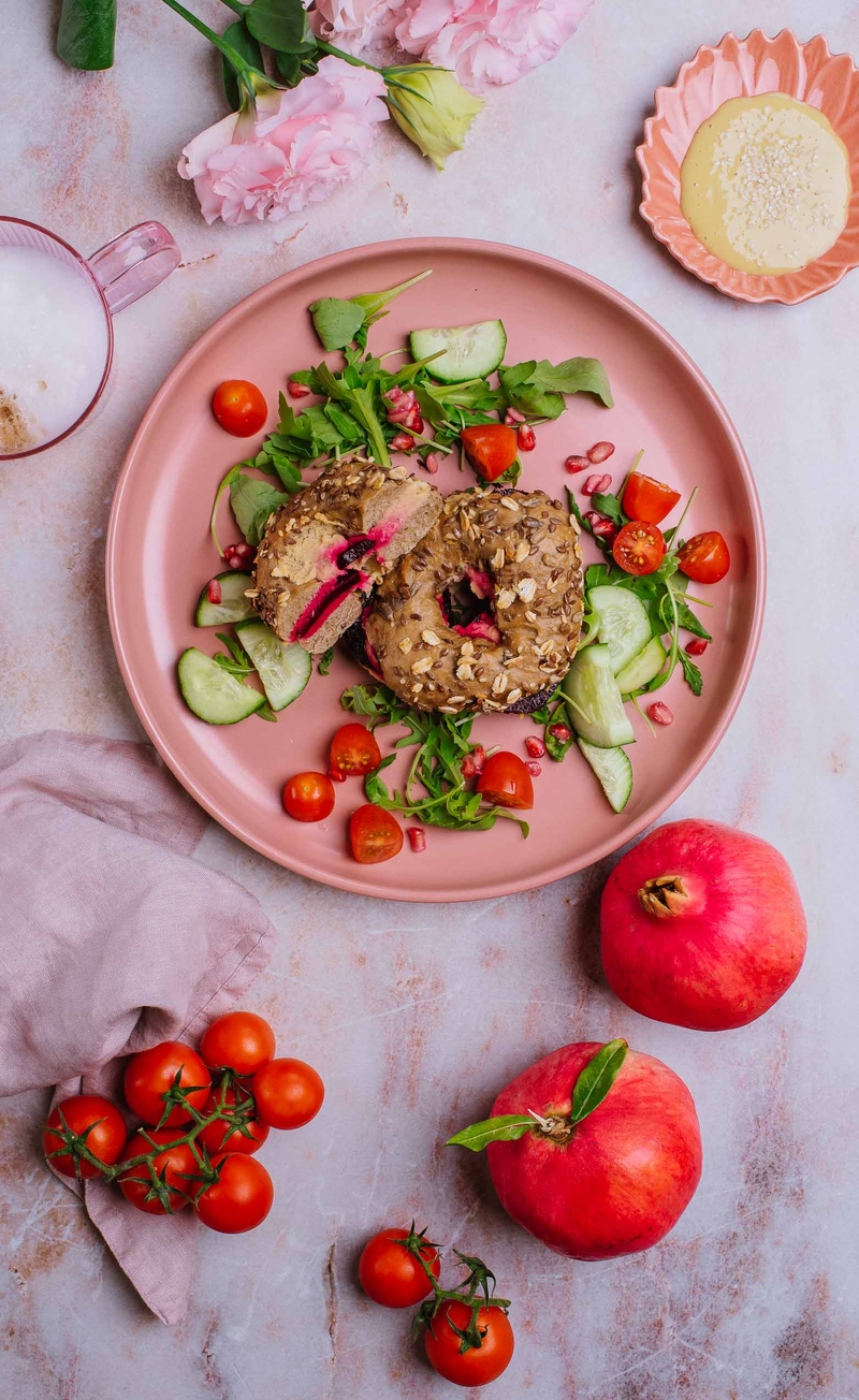 Bajgiel z hummusem i pieczonym buraczkiem, sałatka z granatem, dressing tahini