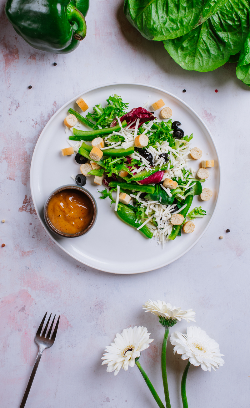Sałatka z roślinnym serem mozzarella, zieloną papryką, czarnymi oliwkami i grzankami, italian dressing