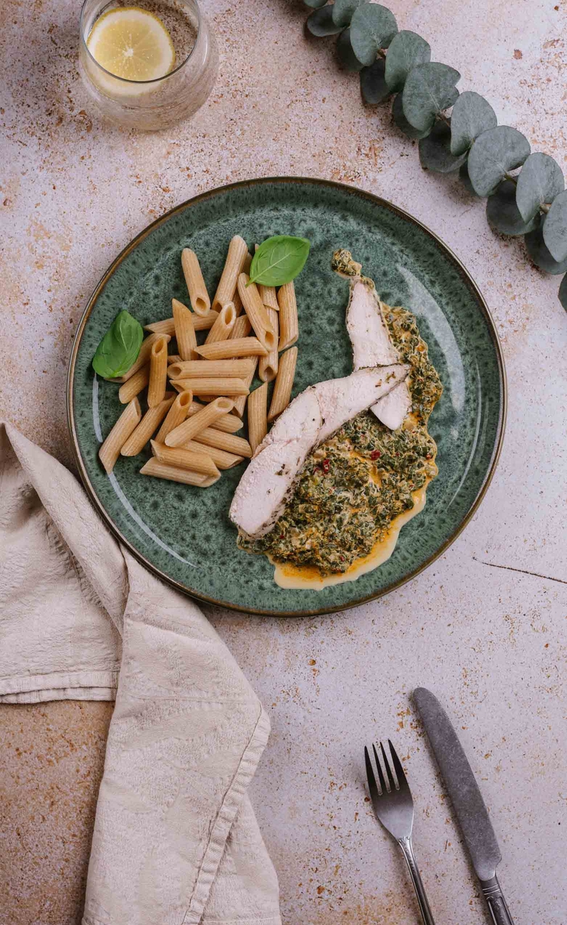 Pełnoziarniste penne w pikantnym śmietanowym sosie z ndują i szpinakiem, plastry kurczaka