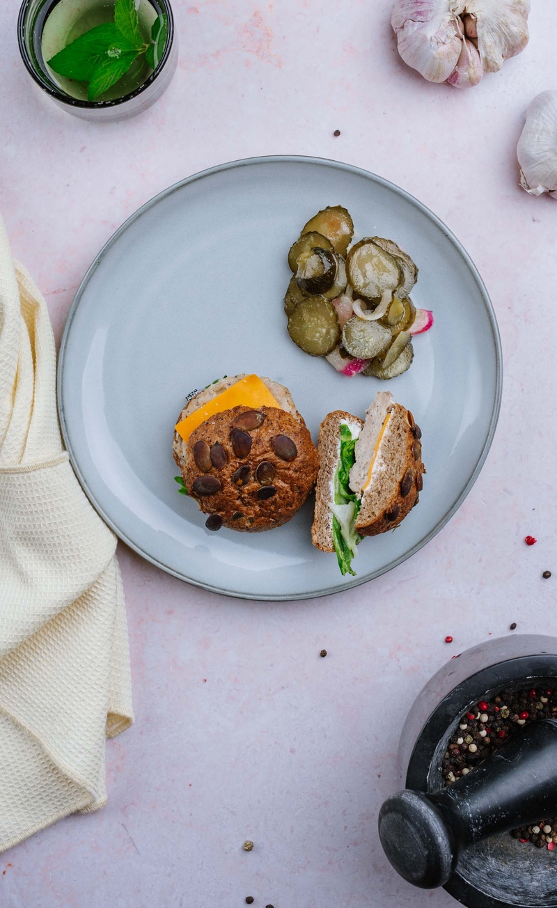 Drobiowy burger z serem cheddar, sałatą i dipem czosnkowym, surówka z ogórków kiszonych z cebulką