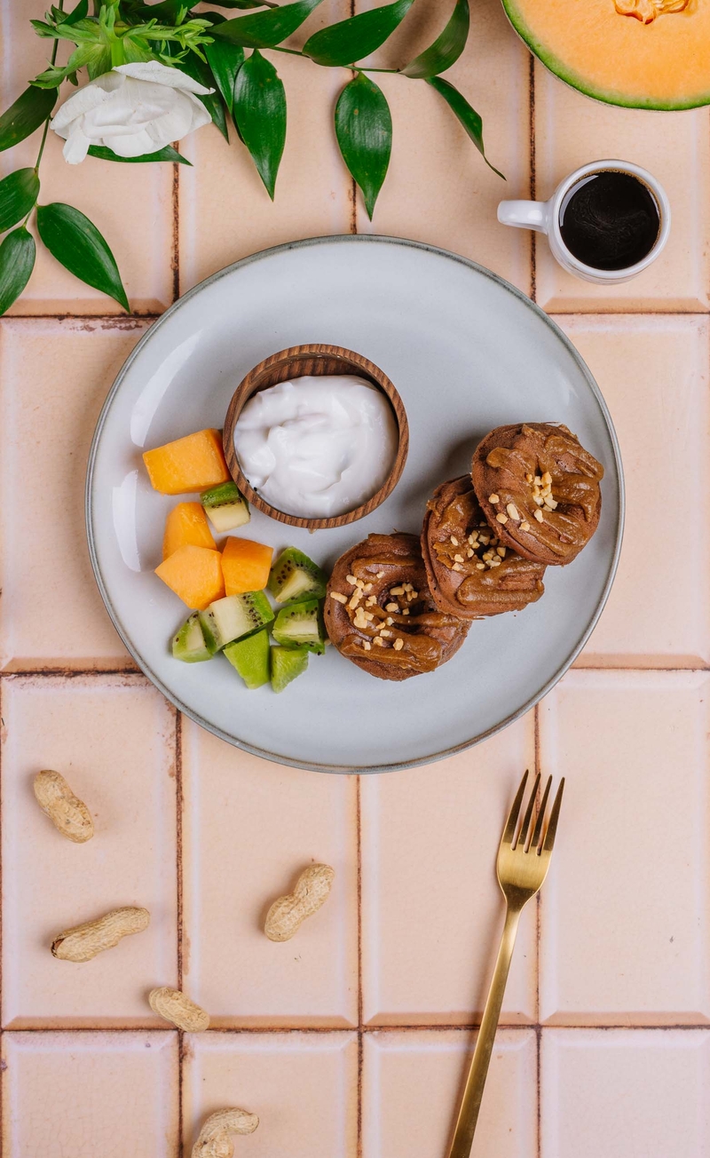 Wegańskie donuty czekoladowe z polewą karmelową i orzeszkami ziemnymi, jogurt kokosowy, melon, kiwi