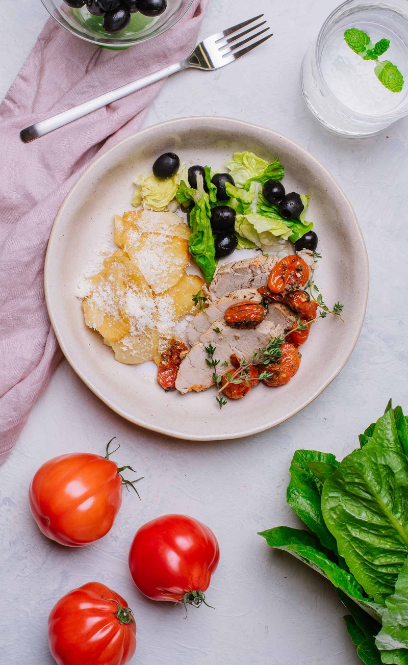 Polędwiczka wieprzowa z pomidorkami confit i oliwą truflową, pieczone talarki ziemniaczane z parmezanem, sałata rzymska z oliwkami