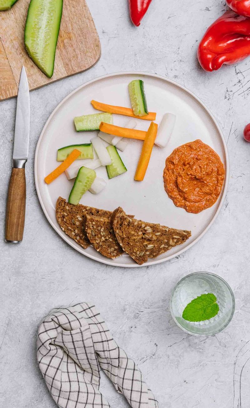 Muhammara czyli pasta z papryki i orzechów włoskich, chleb bezglutenowy, słupki warzyw