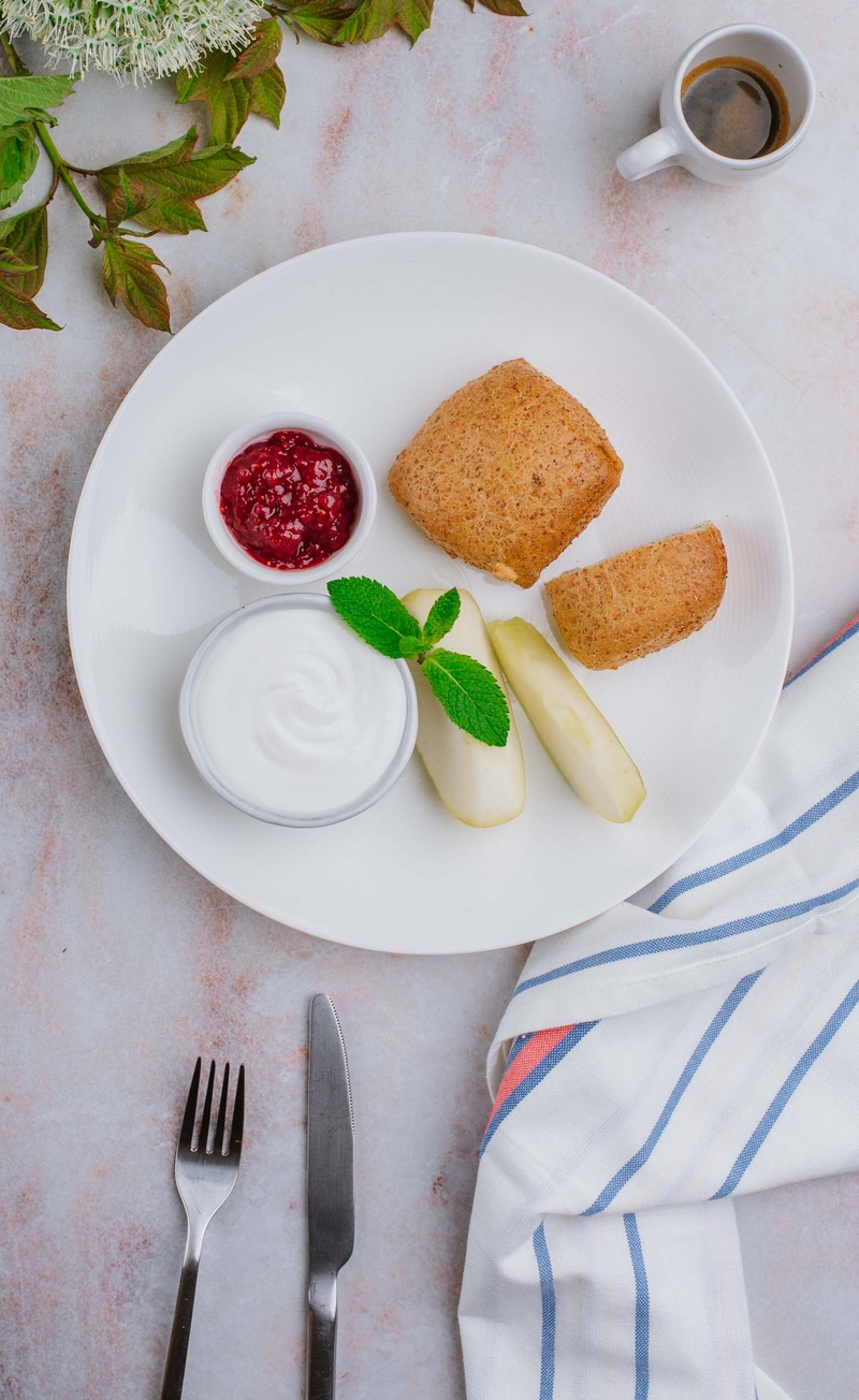 Pełnoziarnista ciabatta z ubitym serkiem wiejskim i konfiturą malinową bez cukru, cząstki jabłka
