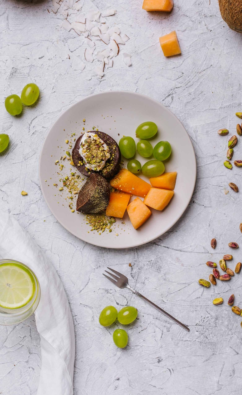 Wegańskie czekoladowe muffinki z bitą śmietaną kokosową i pistacjami, melon, winogrona
