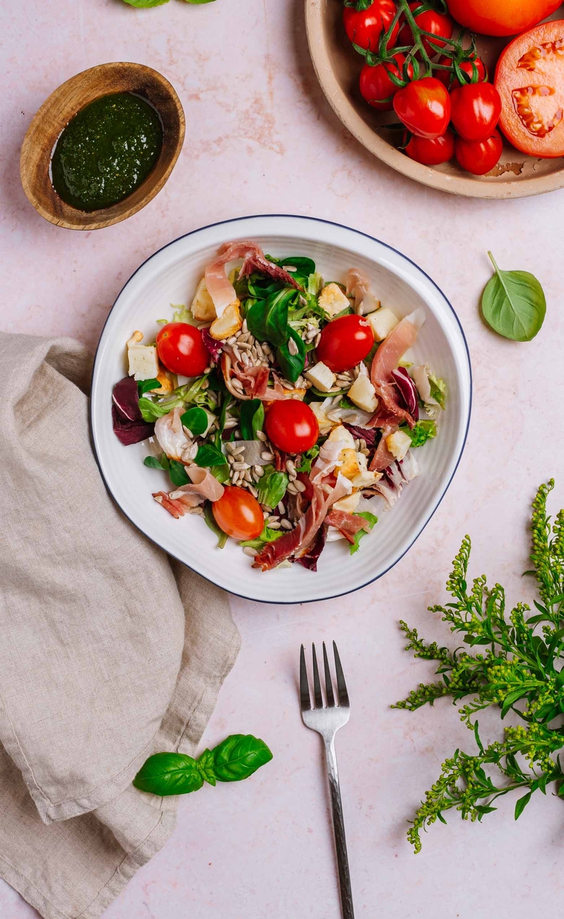 Miks sałat z szynką dojrzewającą, pieczonym halloumi, pomidorkami i nasionami słonecznika, dressing z pesto bazyliowym