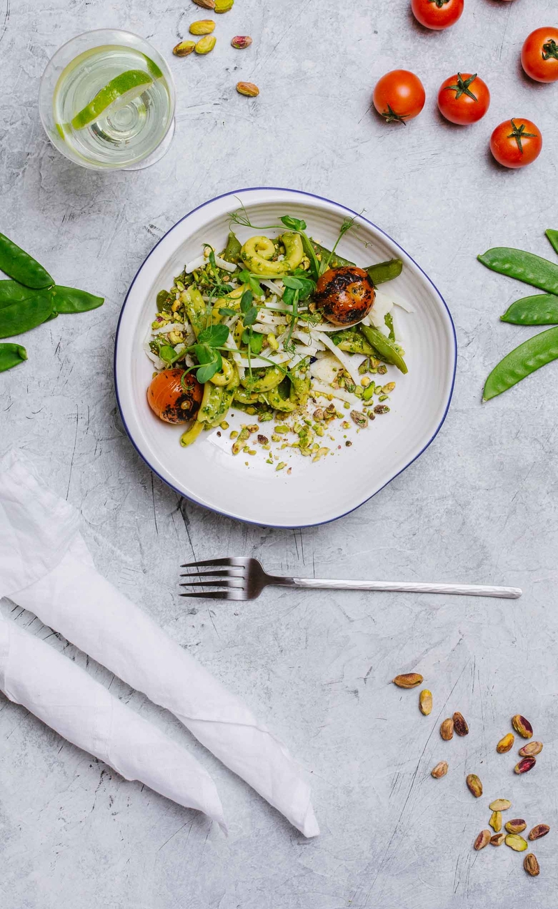 Świeży makaron z pesto, pecorino i pistacjami, groszek cukrowy i pieczone pomidorki