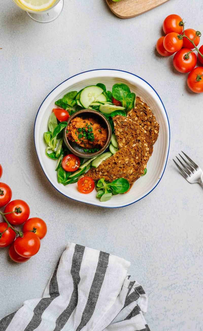 Pomidorowa pasta z pieczonego dorsza ze szczypiorkiem, chleb bezglutenowy z ziarnami, świeże warzywa