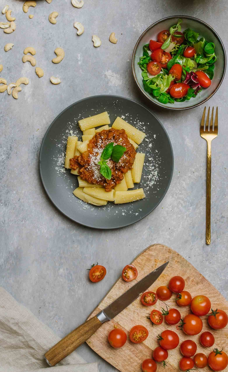 Makaron penne z wegańskim sosem bolońskim, mieszanka sałat z pomidorkami, sos winegret