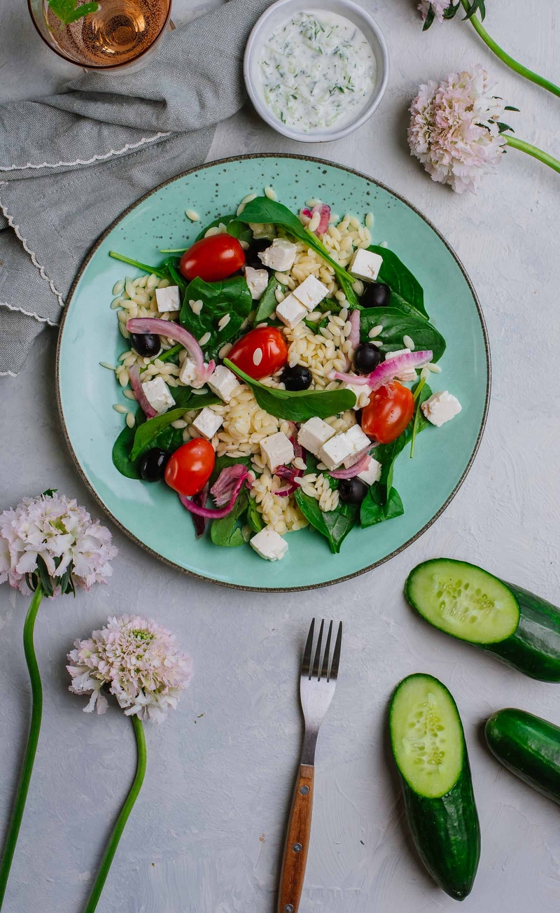 Grecki bowl z serem, marynowanymi oliwkami, makaronem orzo, pomidorami i czerwoną cebulą, dip tzatziki