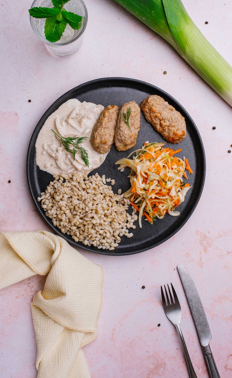 Drobiowe kotleciki nadziewane pieczarkami i serem w sosie śmietanowym, kasza pęczak, surówka porowa