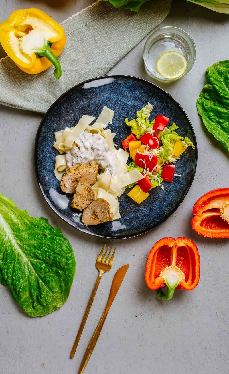 Plastry polędwiczki wieprzowej na truflowym pappardelle z pieczarkami brunatnymi, sałata rzymska z papryką i parmezanem