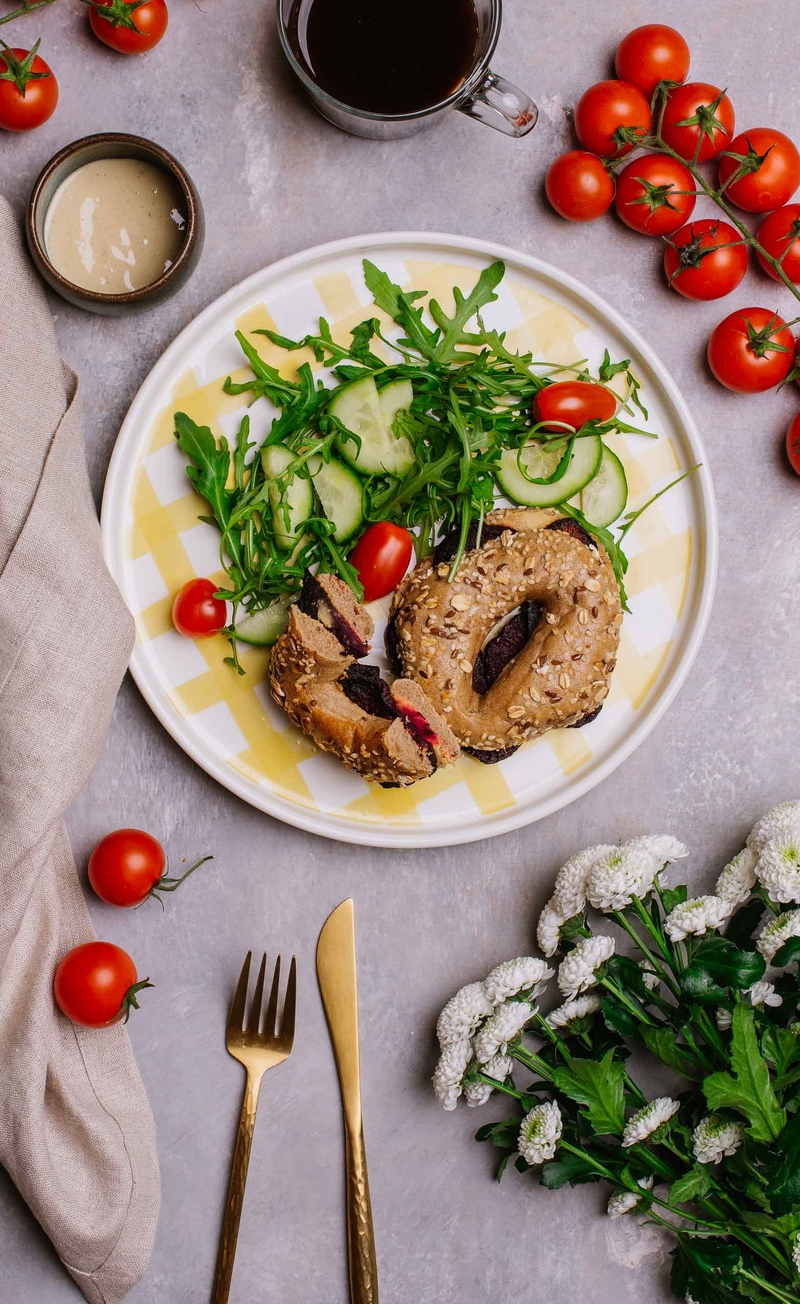 Bajgiel z hummusem i pieczonym burakiem, sałatka z granatem, dressing tahini